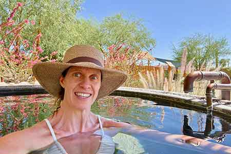 Sally Mitchell yoga teacher soaking in hot mineral springs at yoga retreat