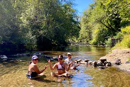 Yoga retreat guests swimming in local creek in Oregon 